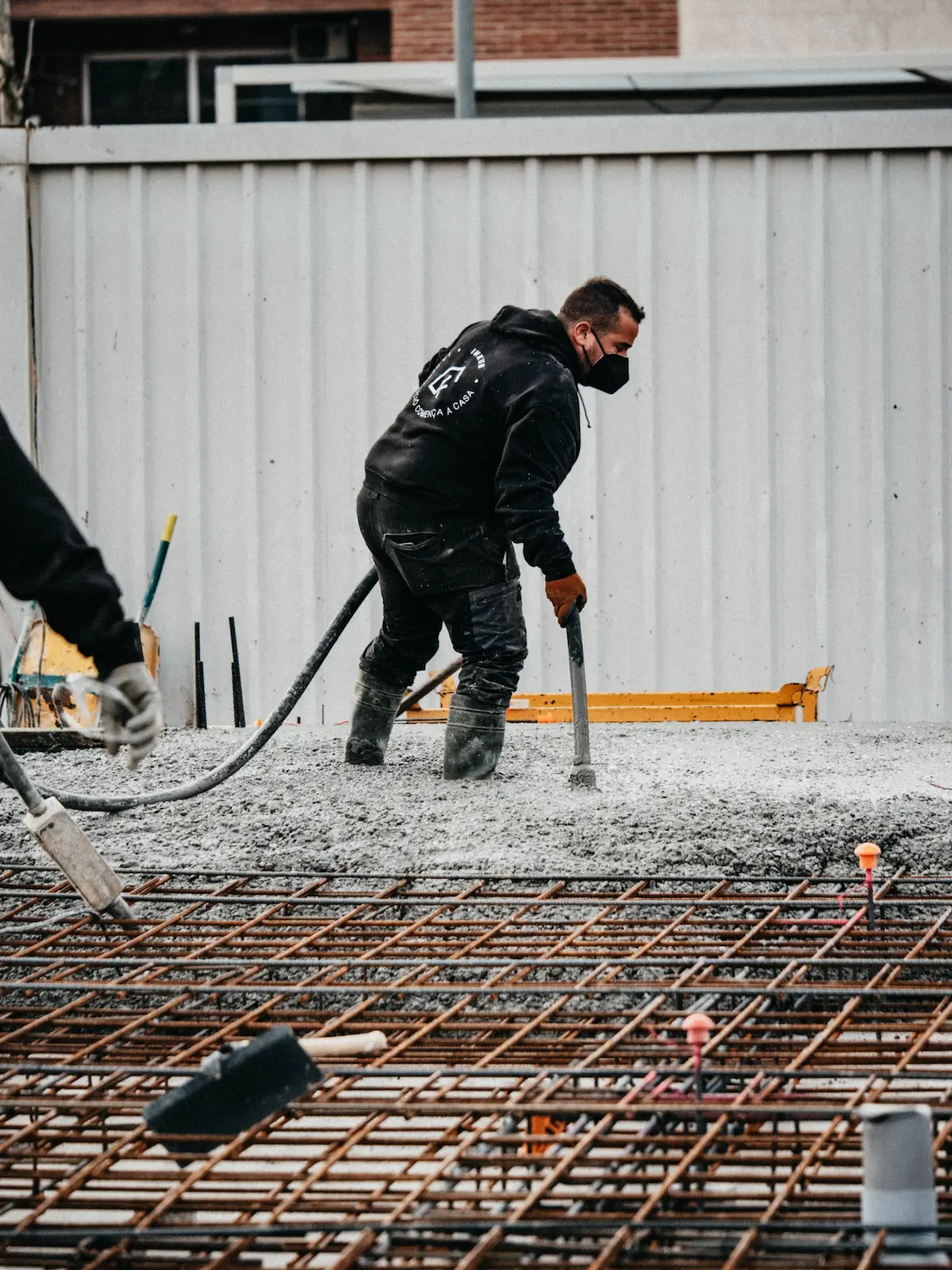 Treballador vibrant el formigó de la llosa